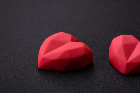 Delicious sweet heart shaped chocolate candies on a dark concrete background. valentines day...