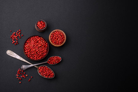 Spice, all spice peas in red or pink color in a wooden bowl on a black concrete background. asian foodの写真素材