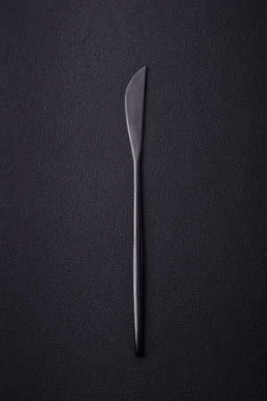Metal kitchen knife on a dark textured concrete background. Cutlery, preparation for dinner