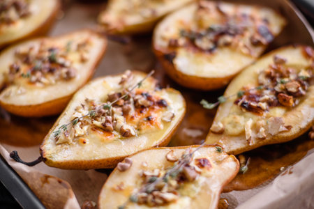 Delicious baked pear with dorblu cheese, walnut and honey on a textured concrete background. Vegetarian dishの写真素材