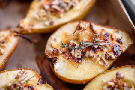 Delicious baked pear with dorblu cheese, walnut and honey on a textured concrete background. Vegetarian dishの写真素材