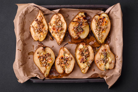 Delicious baked pear with dorblu cheese, walnut and honey on a textured concrete background. Vegetarian dishの写真素材