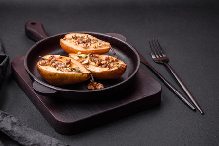 Delicious baked pear with dorblu cheese, walnut and honey on a textured concrete background. Vegetarian dishの写真素材