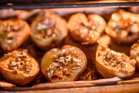 Delicious baked pear with dorblu cheese, walnut and honey on a textured concrete background. Vegetarian dishの写真素材