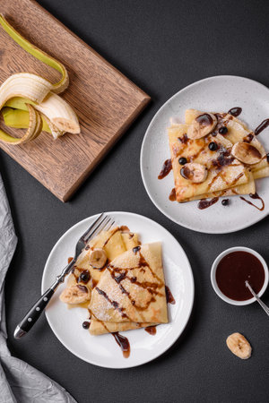 Delicious fresh baked pancakes with honey and fruits on a textured concrete background. Useful healthy foodの写真素材