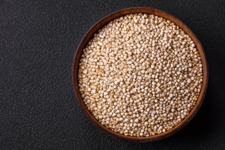 Wholesome raw quinoa in a bowl on a dark concrete background. Useful healthy foodの写真素材