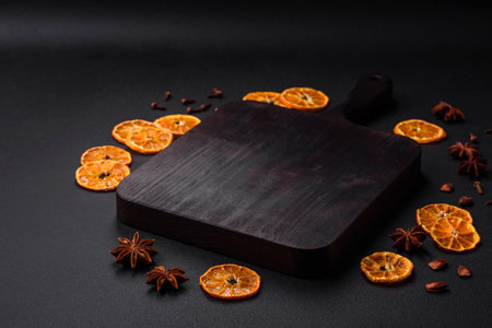 Dried round shape slices of bright orange color tangerine on a dark textural backgroundの写真素材