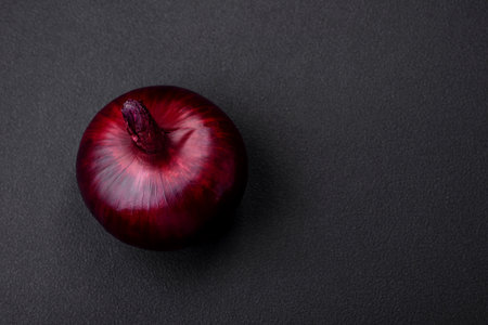Fresh raw red onion on dark textured concrete background. Cooking at homeの写真素材
