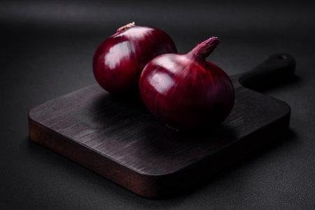 Fresh raw red onion on dark textured concrete background. Cooking at homeの写真素材