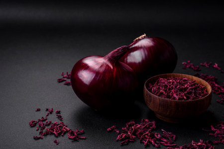 Fresh raw red onion on dark textured concrete background. Cooking at homeの写真素材