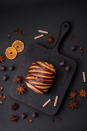 Delicious sweet crispy fresh baked cinnamon bun on dark concrete background