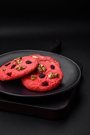 Delicious fresh crunchy pink oatmeal cookies with raspberry flavor on a dark concrete backgroundの写真素材