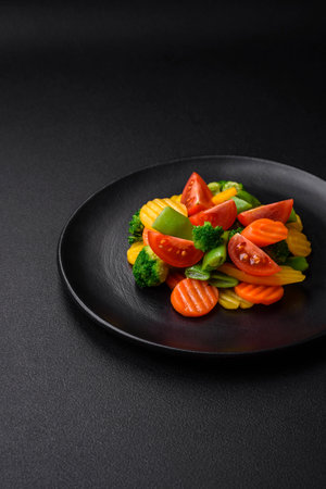 Salad of fresh and steamed vegetables cherry tomatoes, broccoli, carrots and asparagus beans on a dark concrete backgroundの写真素材