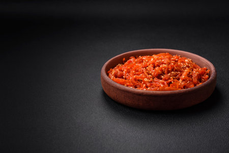 Dried squid chopped into slices and seasoned with sesame seeds and spices on a dark concrete background. Korean food dishの写真素材