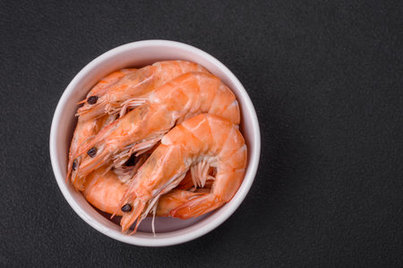Tiger shrimp or langoustine boiled with spices and salt on a dark concrete backgroundの写真素材