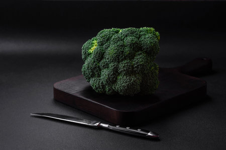 Raw fresh broccoli on a black home kitchen table. Cooking vegan foodの写真素材