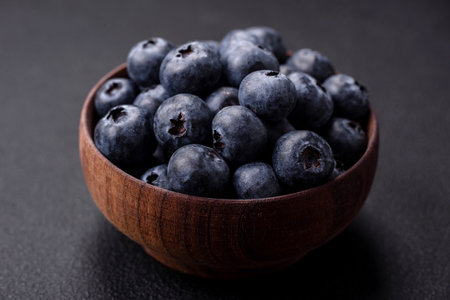 Delicious fresh blueberries on a textural black concrete background. Harvesting seasonal berriesの写真素材