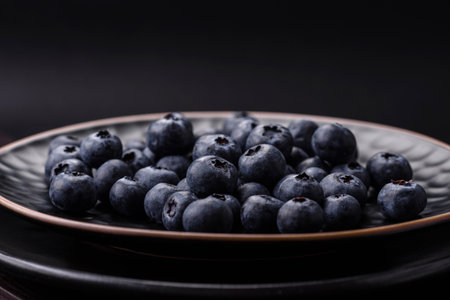 Delicious fresh blueberries on a textural black concrete background. Harvesting seasonal berries