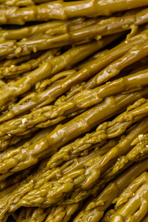 Sprigs of delicious canned asparagus on a black ceramic plate on a dark concrete backgroundの写真素材