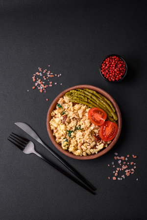 Delicious scramble with salmon, sun-dried tomatoes, spinach, spices and herbs on a dark backgroundの写真素材