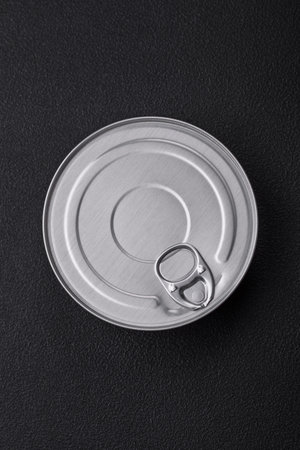 Tin metal can with canned food round shape with a key on a dark concrete backgroundの写真素材