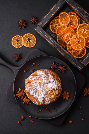 Delicious fresh christmas pie with fruit and raisin panettone on a dark concrete backgroundの写真素材