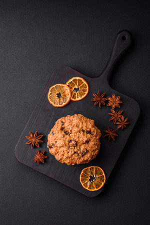 Delicious baked oatmeal raisin cookies on a dark concrete background. Sweets for breakfastの写真素材
