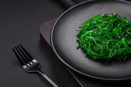 Delicious healthy vegetarian hiashi wakume seafood salad with sesame seeds on a dark concrete backgroundの写真素材