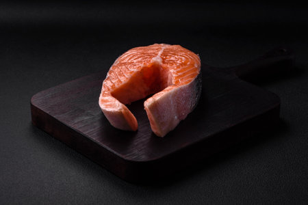 Fresh raw salmon steak with spices and herbs prepared for grilled baking. healthy seafood food