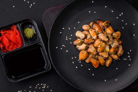 Delicious marinated mussels with spices and herbs on a ceramic plate on a dark concrete backgroundの写真素材