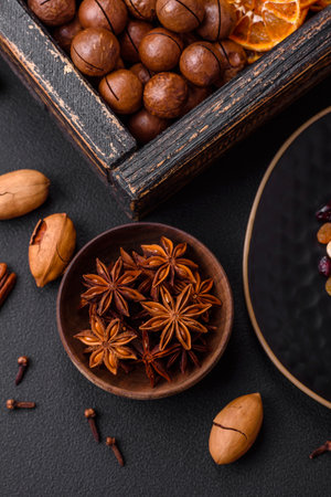Roasted pecans and macadamia nuts, dried tangerine, dried berries on a dark concrete backgroundの写真素材