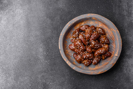 Chicken hearts fried in soy sauce with salt and spices in a plate on a textured concrete backgroundの写真素材
