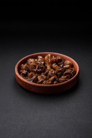 Delicious champignon mushrooms with salt, spices and herbs grilled in a ceramic plate