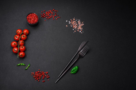 Ingredients for cooking cherry tomatoes, salt, spices and herbs on a dark concrete backgroundの写真素材