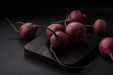 Fresh raw beetroot in the form of tubers on a textured concrete background. Vegetarian Ingredients