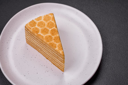 Delicious fresh sweet honey cake layer cake with white cream on textured concrete backgroundの写真素材
