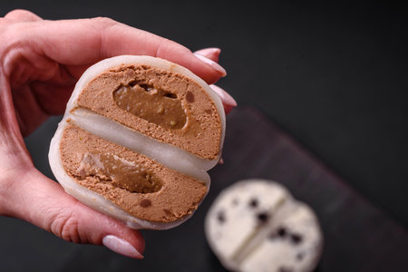 Delicious sweet mochi dessert with toppings on a dark concrete background. Nutritious vegetarian...