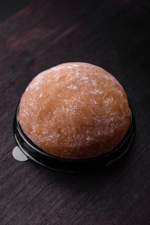 Delicious sweet mochi dessert with toppings on a dark concrete background. Nutritious vegetarian...