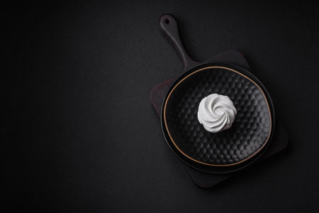 Delicious sweet colored marshmallow on a dark concrete background. Healthy sweets for the dinner tableの写真素材