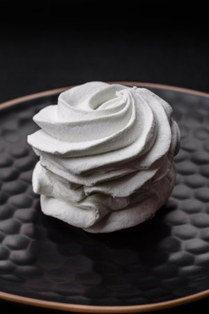 Delicious sweet colored marshmallow on a dark concrete background. Healthy sweets for the dinner...