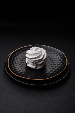 Delicious sweet colored marshmallow on a dark concrete background. Healthy sweets for the dinner...