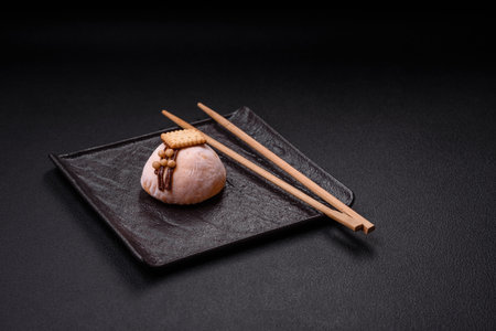 Delicious sweet colorful mochi desserts or ice cream with rice dough and toppings on a dark concrete backgroundの写真素材