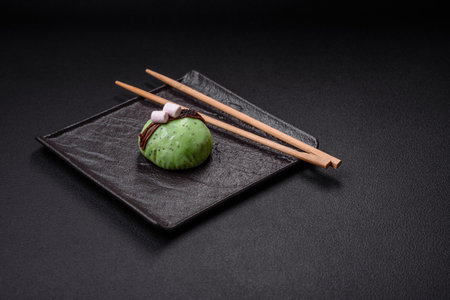 Delicious sweet colorful mochi desserts or ice cream with rice dough and toppings on a dark concrete backgroundの写真素材