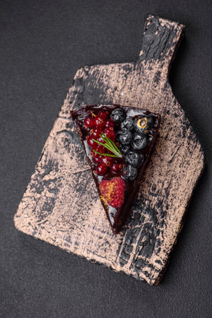 Delicious sweet chocolate brownie cake with blueberries, currants and raspberries on a ceramic plateの写真素材