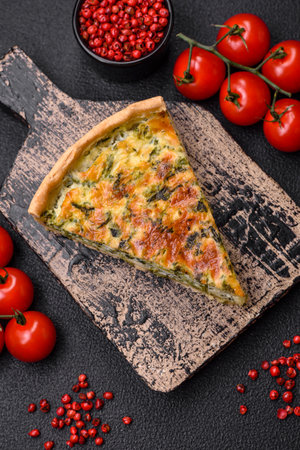 Delicious fresh quiche with broccoli, cheese, spices and herbs cut into pieces on a dark concrete...