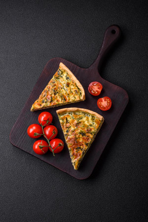 Delicious fresh quiche with broccoli, cheese, spices and herbs cut into pieces on a dark concrete...