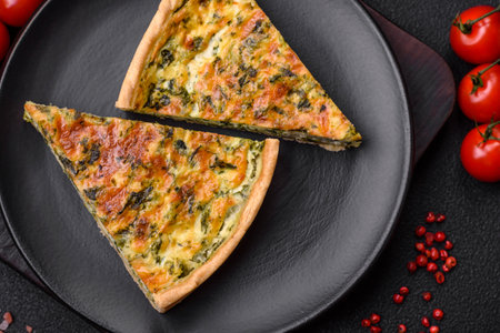 Delicious fresh quiche with broccoli, cheese, spices and herbs cut into pieces on a dark concrete...