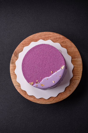 Delicious fresh sweet mousse cake with berry filling topped with pink velvet topping on dark...