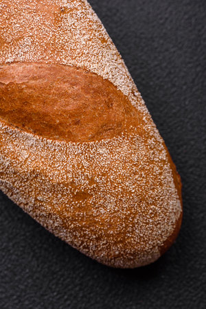 French baguette bread on a dark textured concrete background. Making delicious bruschetta at home