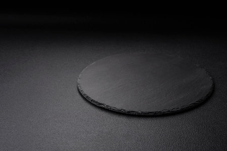 Empty black plate over dark stone background with copy space. top viewの写真素材